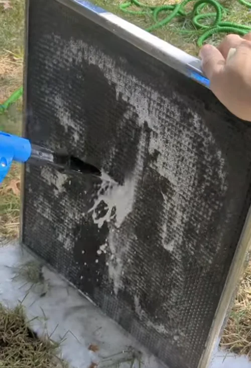 Nettoyage du filtre à air amovible d'une thermopompe murale sous l'eau courante