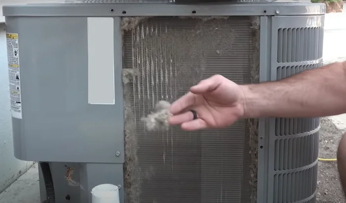 Nettoyage préliminaire : retrait manuel des gros débris autour de l'unité extérieure