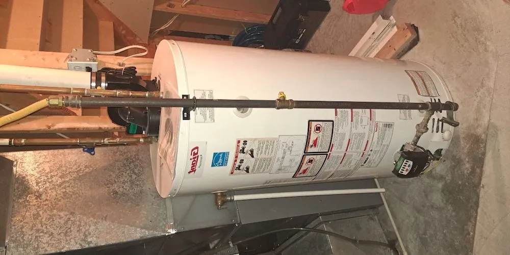 Un grand chauffe-eau au gaz de marque « Giant » dans un sous-sol, montrant des étiquettes de sécurité, un logo Energy Star et une soupape de commande de gaz au bas.